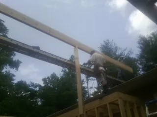 Carpenter setting a ridge beam over a new addition frame — Ice Dam Removal by Roofing Brothers in Gentryville