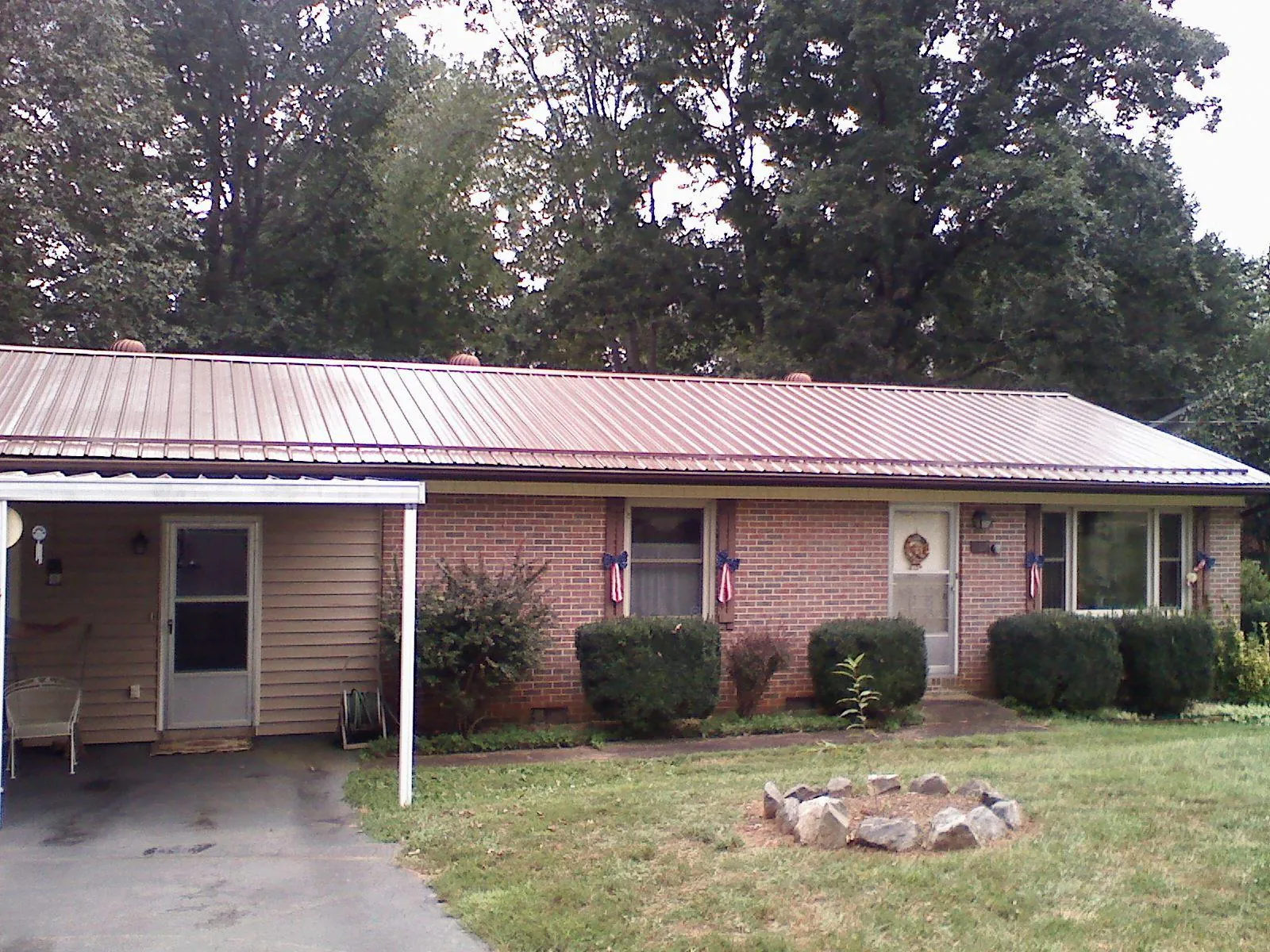 Bronze metal roof and carport on a brick ranch home — Roof Repair work by our crew in Gentryville